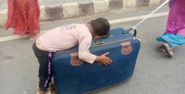 Mom carry his sleeping son on suitcase video goes viral