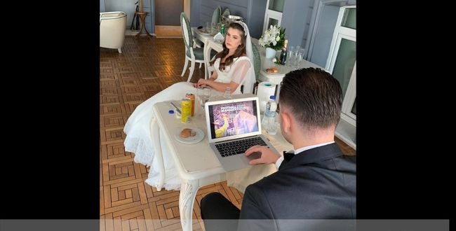 Groom playing game in laptop at marriage event