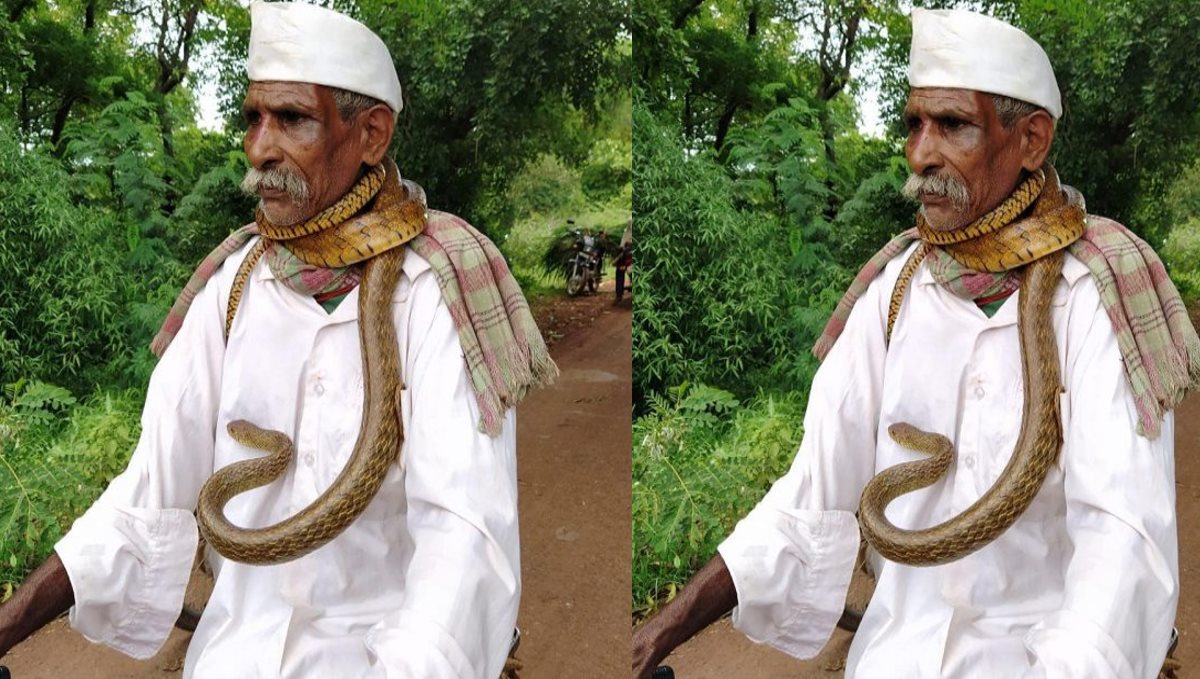 old-man-wraps-snake-around-his-neck-and-rides-a-cycle-v