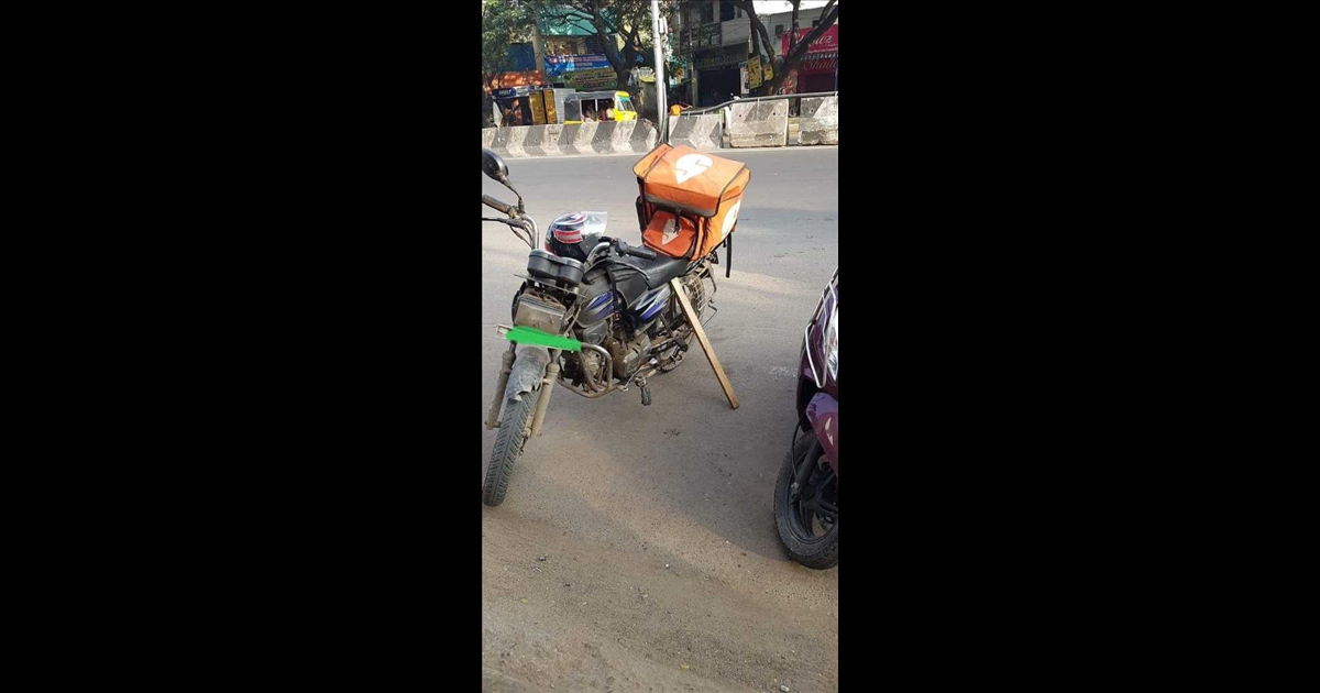 swiggy-delivery-man-use-wooden-piece-to-stand-two-wheel